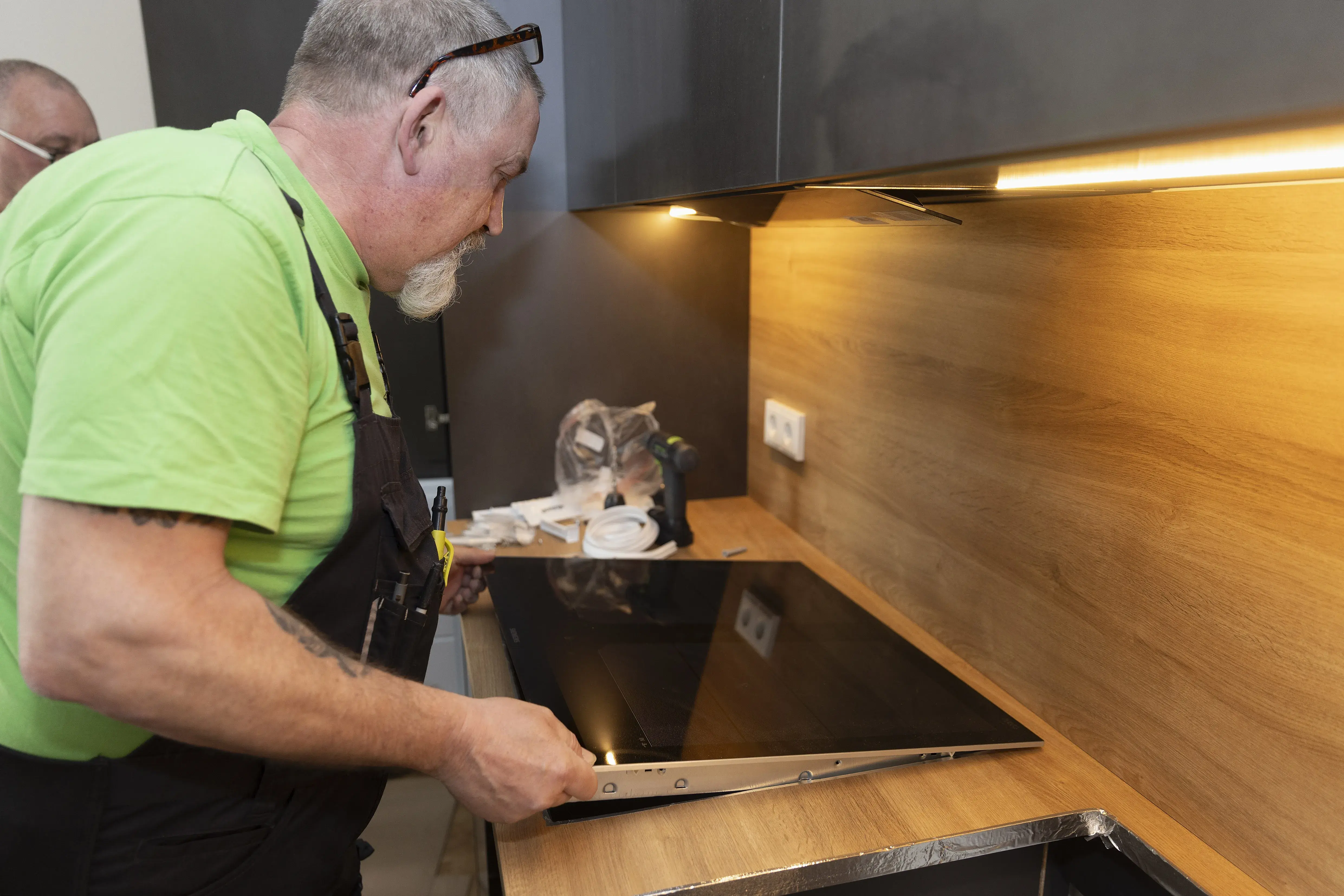 Handwerker installiert ein Kochfeld in einer modernen Küche